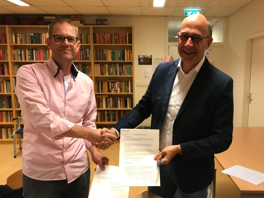 Marcel van Oort in zijn nopjes met het getekende contract, samen met Hans Tuit.